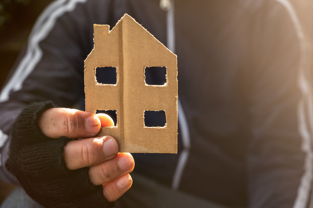 Homeless Man Holds A House Made Of Cardboard In His Hand