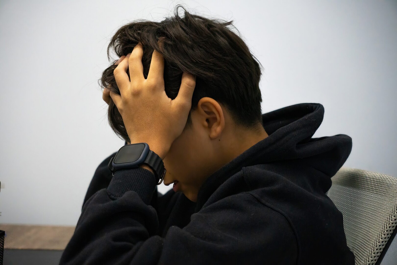 Frustrated Young Boy Holding Head After Smartphone Disappointment